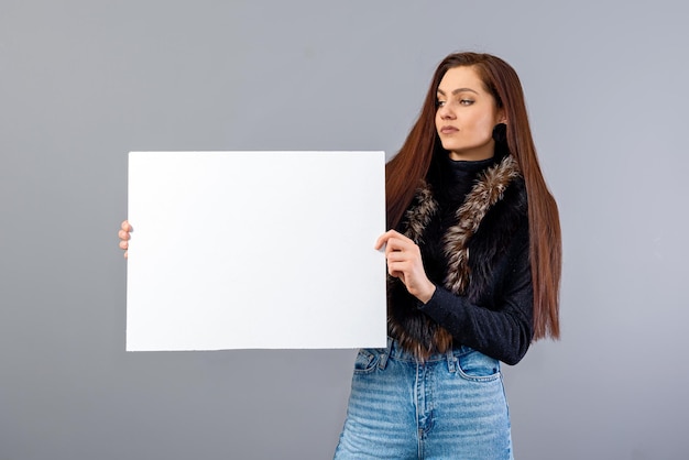 elegante jonge tiener vrouw met leeg bord met kopie ruimte geïsoleerd op grijs