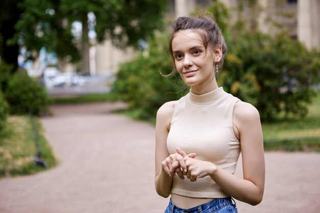 Elegante jonge vrouw loopt overdag in de stadstuin