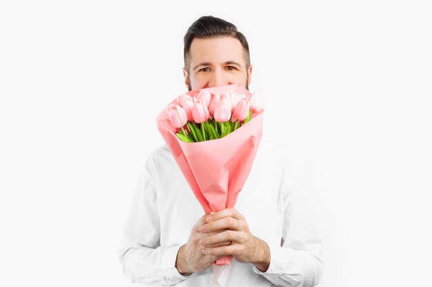 Elegante man met een baard met een boeket tulpen, een geschenk voor Valentijnsdag