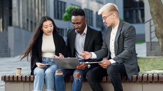 Elegante multiraciale collega's zitten op de bank bij het kantoor en bespreken zakelijke zaken.