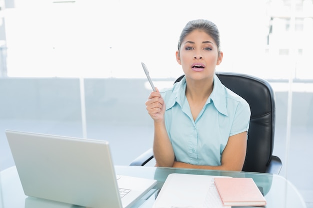 Elegante onderneemster met laptop op kantoor