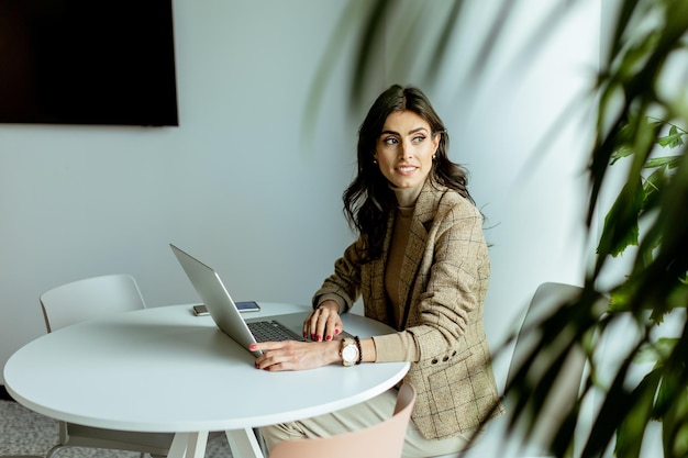 Elegante professionele vrouw die aan haar laptop werkt in een moderne kantoorruimte