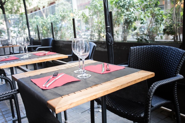 Elegante restauranttafel met bestek, servies en glazen.