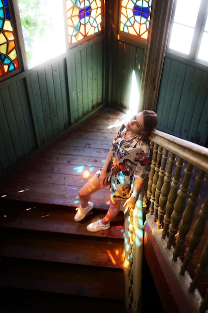 Elegante slanke vrouw poseert op de trap in het zonlicht