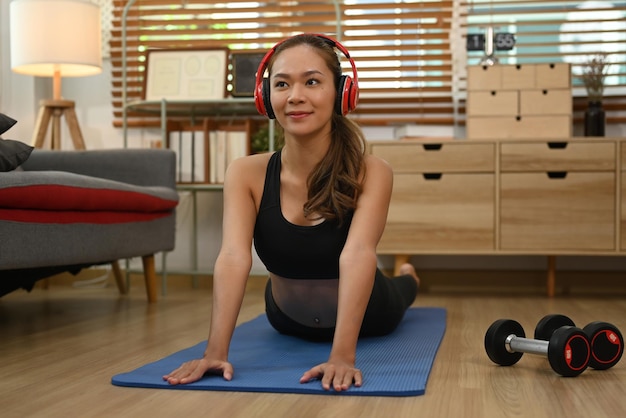 Elegante vrouw die yoga beoefent en hoge cobra-asana doet op een mat Fitness workout gezonde levensstijl concept