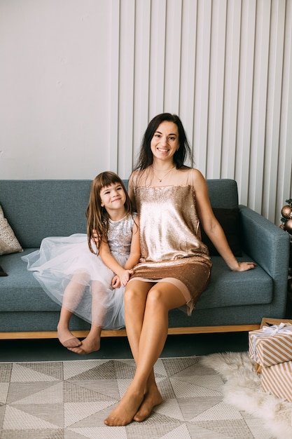 Elegante vrouw met haar dochter die Kerstmis thuis viert