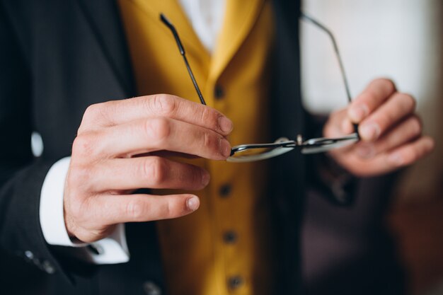 Elegante zakenman in een klassiek kostuum dat op zonnebril zet