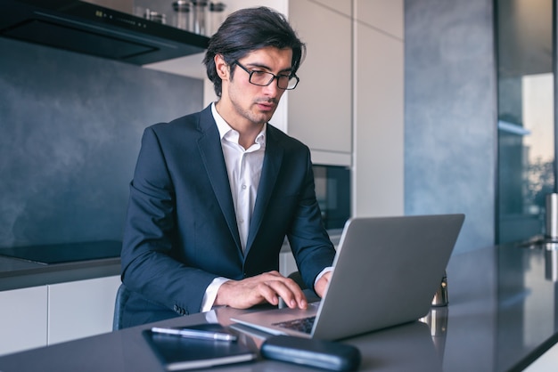 Elegante zakenman werkt vanuit huis met een laptop. Telewerken concept