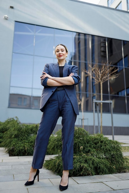 Elegante zakenvrouw met gekruiste arm poseren buitenshuis