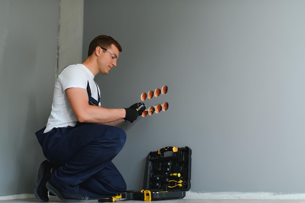 Elektricien aan het werk op schakelaars en stopcontacten van een residentieel elektrisch systeem