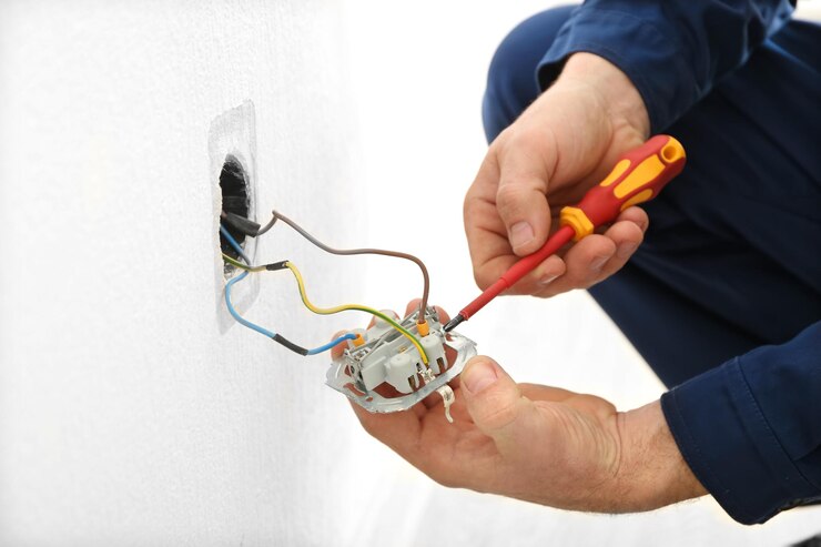 Foto elektricien demonteert een stopcontact in een nieuw gebouw