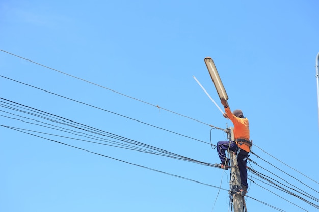 Elektricien die hoogspanningslijnen herstellen en bol vervangen