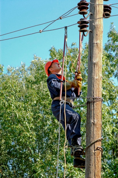 Elektricien installeert aarding op een hoogspanningslijn voordat deze wordt gerepareerd.