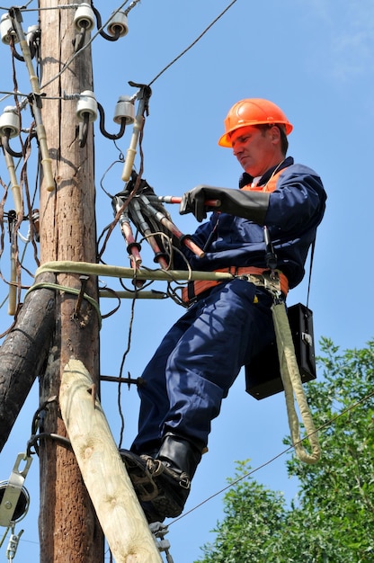 Elektricien lineman reparateur werknemer installeert de aarding op de hoogspanningslijn voordat deze wordt gerepareerd.