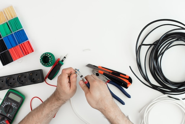 Elektricien werkt met een stuk gereedschap. tools op witte achtergrond