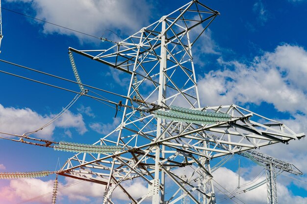 Elektriciteitsmasten met de stroomvoorziening over een landelijk landschap tijdens zonnige zomerdag Selectieve aandacht Stockfoto