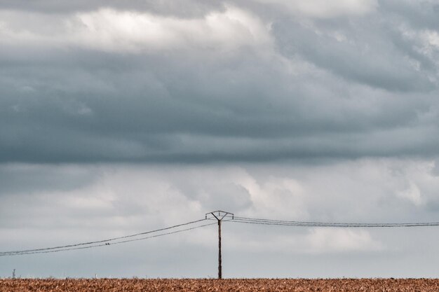 Foto elektriciteitspylon op het veld tegen bewolkte lucht