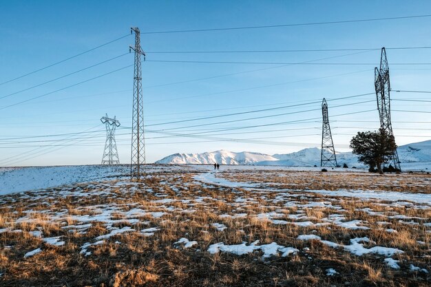 Elektriciteitspylon op sneeuw bedekt land tegen de lucht