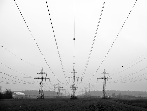 Elektriciteitspylonen op het veld tegen een heldere lucht
