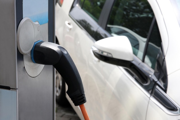 Elektrische auto wordt opgeladen op het station close-up van de aangesloten voeding