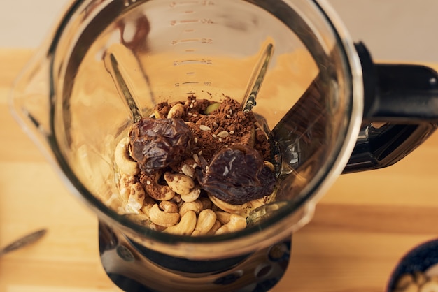 Elektrische blender met ingrediënten voor smoothie die op tafel staat