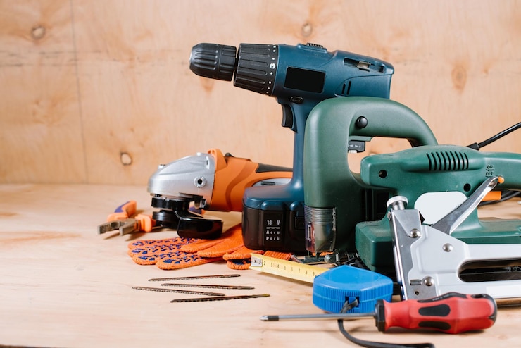 Elektrische bouw- en knutselinstrumenten en gereedschappen op de houten ondergrond