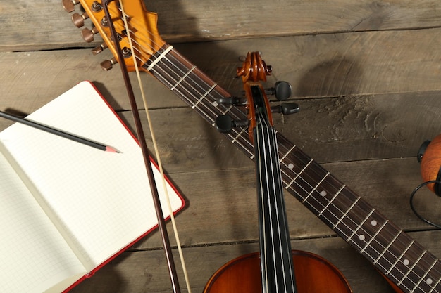 Elektrische gitaar viool sopraansaxofoon en boek op houten achtergrond