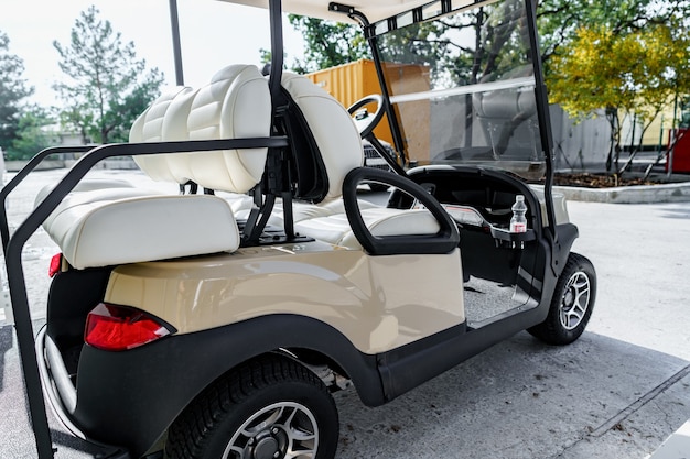 Elektrische golfwagen geparkeerd op parkeerplaats bij hotelgebouw