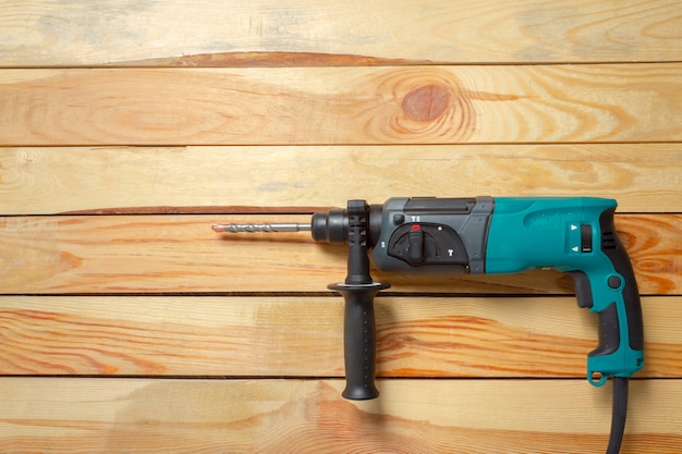 Foto elektrische hamerboor ligt op een houten tafel