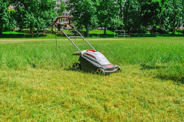 Foto elektrische hand grasmaaier bij het verzorgen van het gras van het stadion op het sportveld