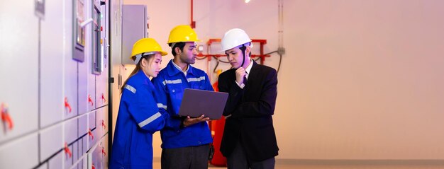 Elektrische schakelpaneelkamer Aziatisch professioneel elektrisch ingenieur-team dat met laptopcomputer werkt voor service en onderhoud in de kamer van HVAC-controlepanelen in een nieuw modern gebouw