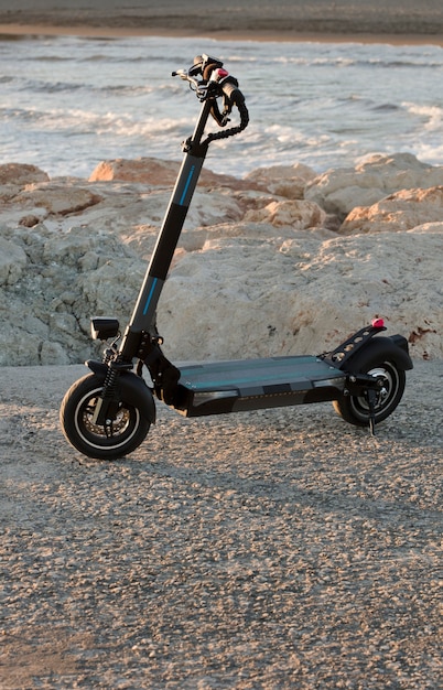 Foto elektrische scooter bij het strand bij zonsondergang