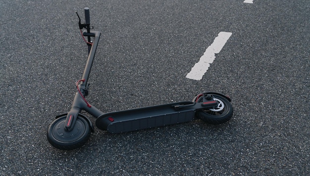 Elektrische scooter of escooter ligt op de weg na een ongeval Elektrisch stedelijk vervoer concept afbeelding