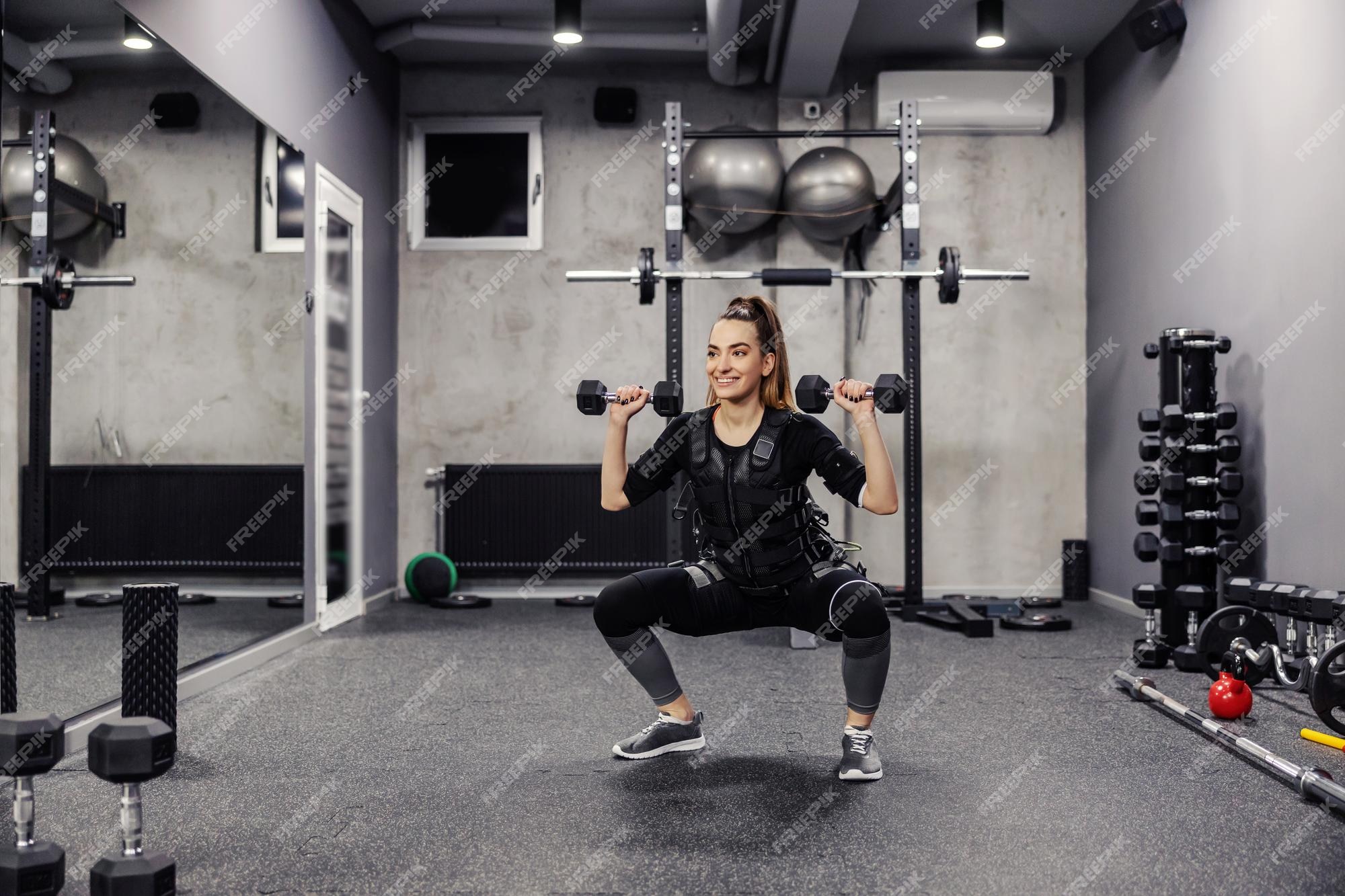 dealer Glimlach afvoer Elektrische spierstimulatie een jonge, gezonde vrouw in een speciaal zwart  ems-pak doet squats | Premium Foto