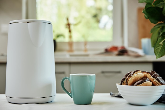 Elektrische waterkoker en kopje thee op tafel