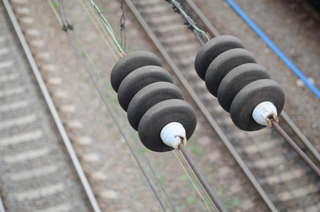 Elektroisolatie op de contactdraden op de achtergrond van een vaag spoorwegspoor. macrofoto met selectieve nadruk