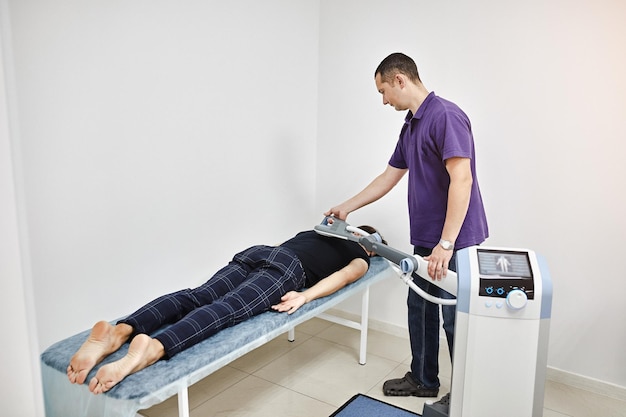 Elektromagnetische therapie van de rug Fysiotherapeut-arts gebruikt medische apparatuur voor zeer effectieve pijnbehandeling en ontsteking Terug De magnetische veldrevalidatie Magnetotherapie