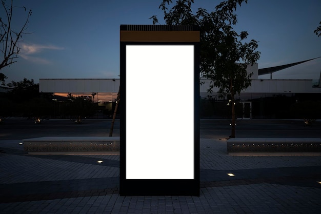 Elektronisch modern leeg scorebord op de achtergrond van een stadsstraat in de avond lege mock up van verticale straatposter billboard op stadsachtergrond