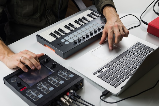 Elektronische muziek produceren op een laptop met draagbaar midi-toetsenbord en elektronische effectprocessors
