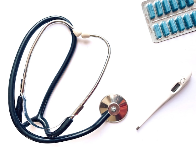 Elektronische thermometer, tonometer en pillen op een witte achtergrond. Geneeskunde en gezondheid concept. Medische sjabloon.