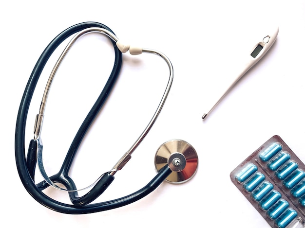 Foto elektronische thermometer, tonometer en pillen op een witte achtergrond. geneeskunde en gezondheid concept. medische sjabloon.