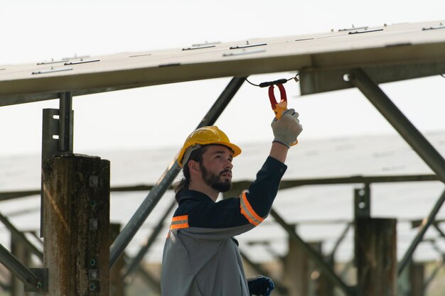 Elektrotechnici inspecteren en onderhouden zonnecellen bij een zonnecelpaneel midden op honderd hectare gras