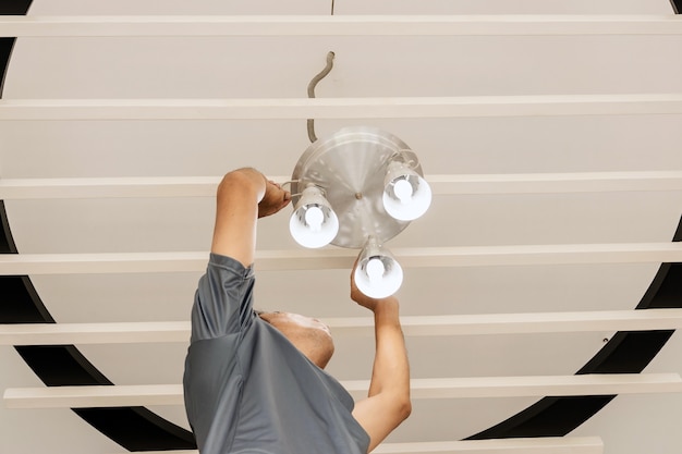 Elektrotechnisch ingenieurs installeren plafondlampen in de gang.