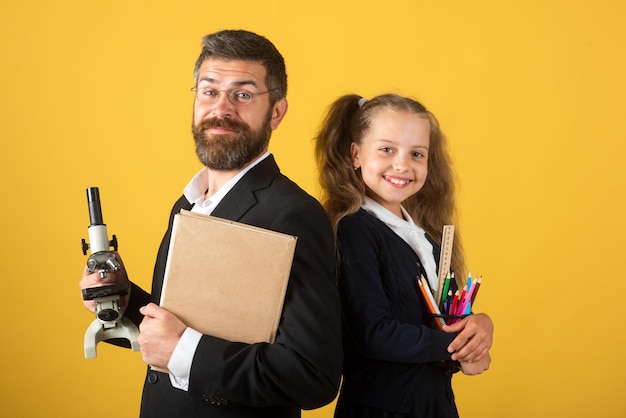 Elementary pupil with teacher in studio isolated teacher with happy schoolgirl portrait of funny sch