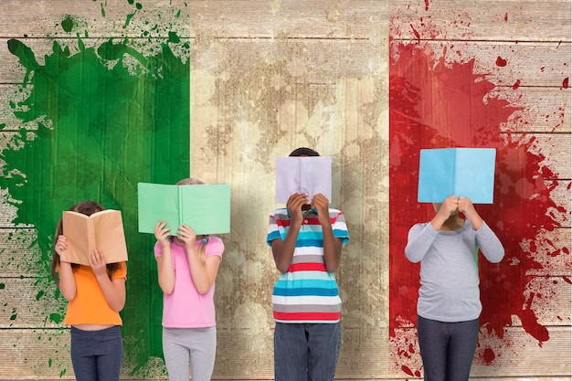 Photo elementary pupils reading against italy flag in grunge effect