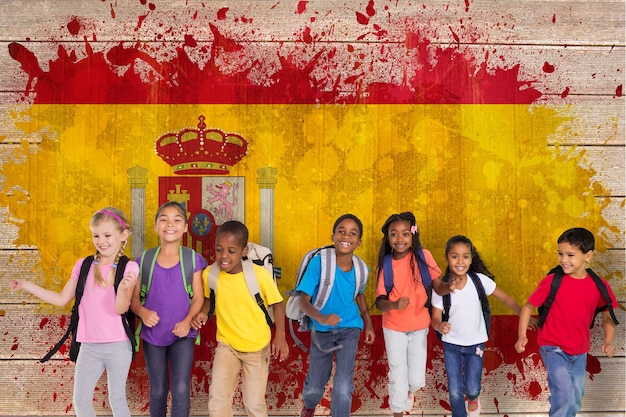 Elementary pupils running against spain flag in grunge effect