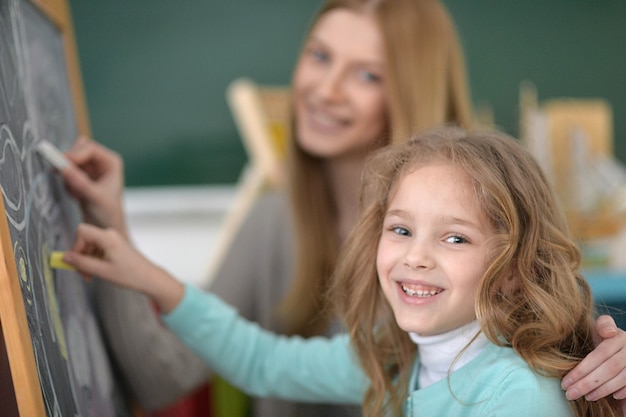 Foto lezione d'arte della scuola elementare con una bella insegnante