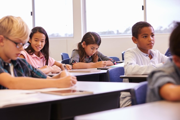 Elementary school kids working at their desks in a classroom