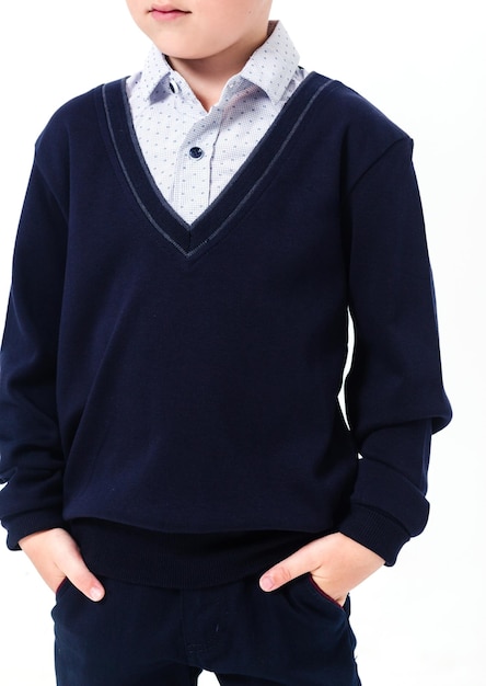 Elementary school student posing in a shirt and black sweater on a white background Vertical photo