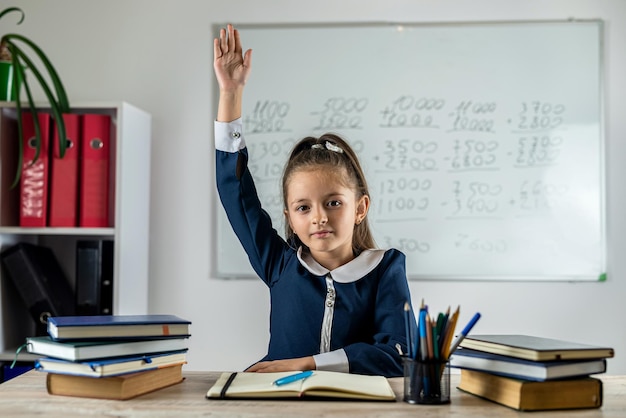 Elementary school student raises her hand because she is ready answer the teacher's question